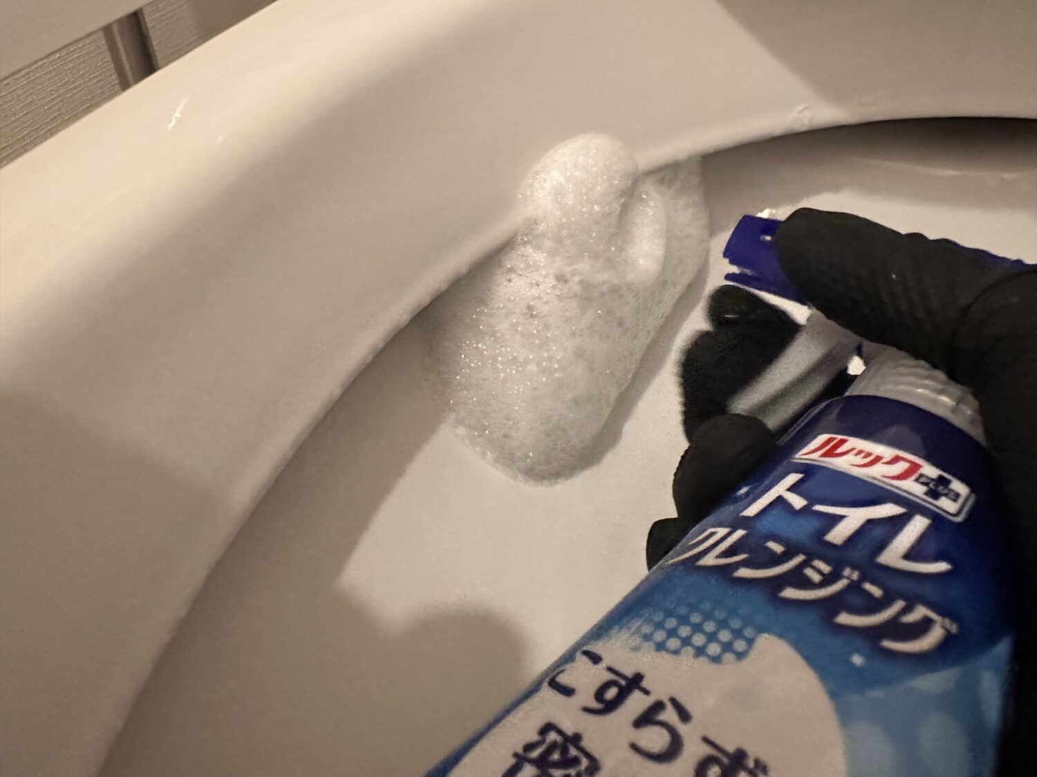 ルックプラストイレクレンジングを便器のフチ裏にスプレーしている様子