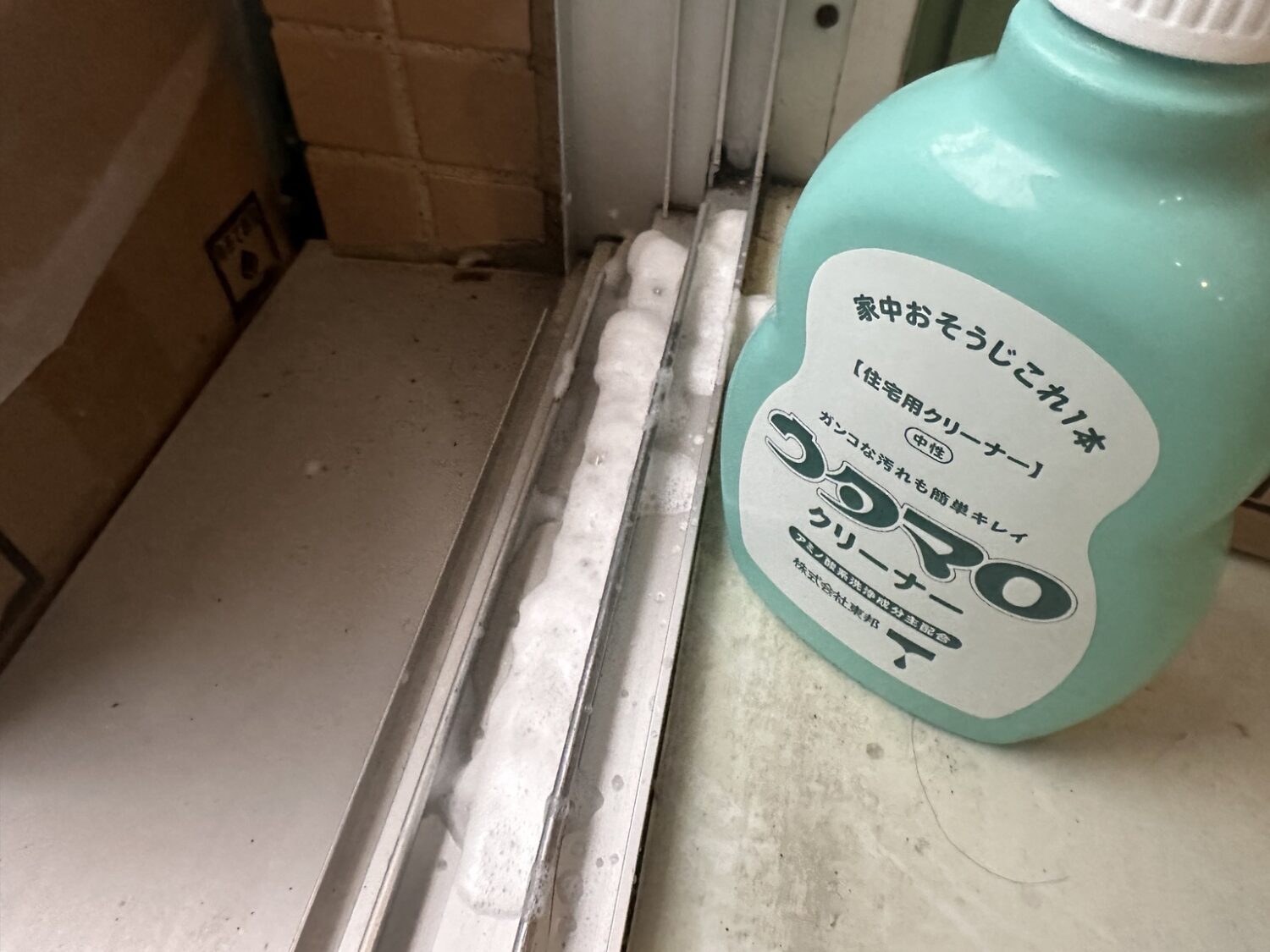 窓サッシレールに中性クリーナーを使って残った汚れをゆるめる様子