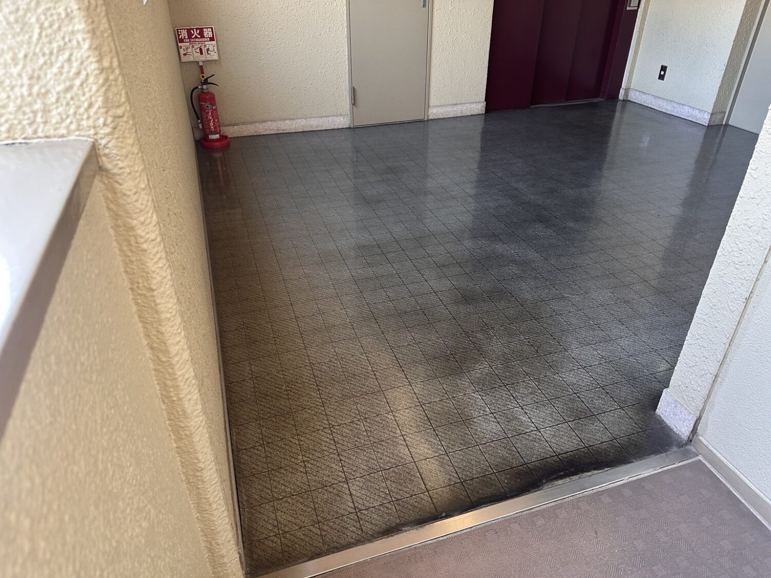 剥離前の築古分譲マンション共用部床の黒ずみ