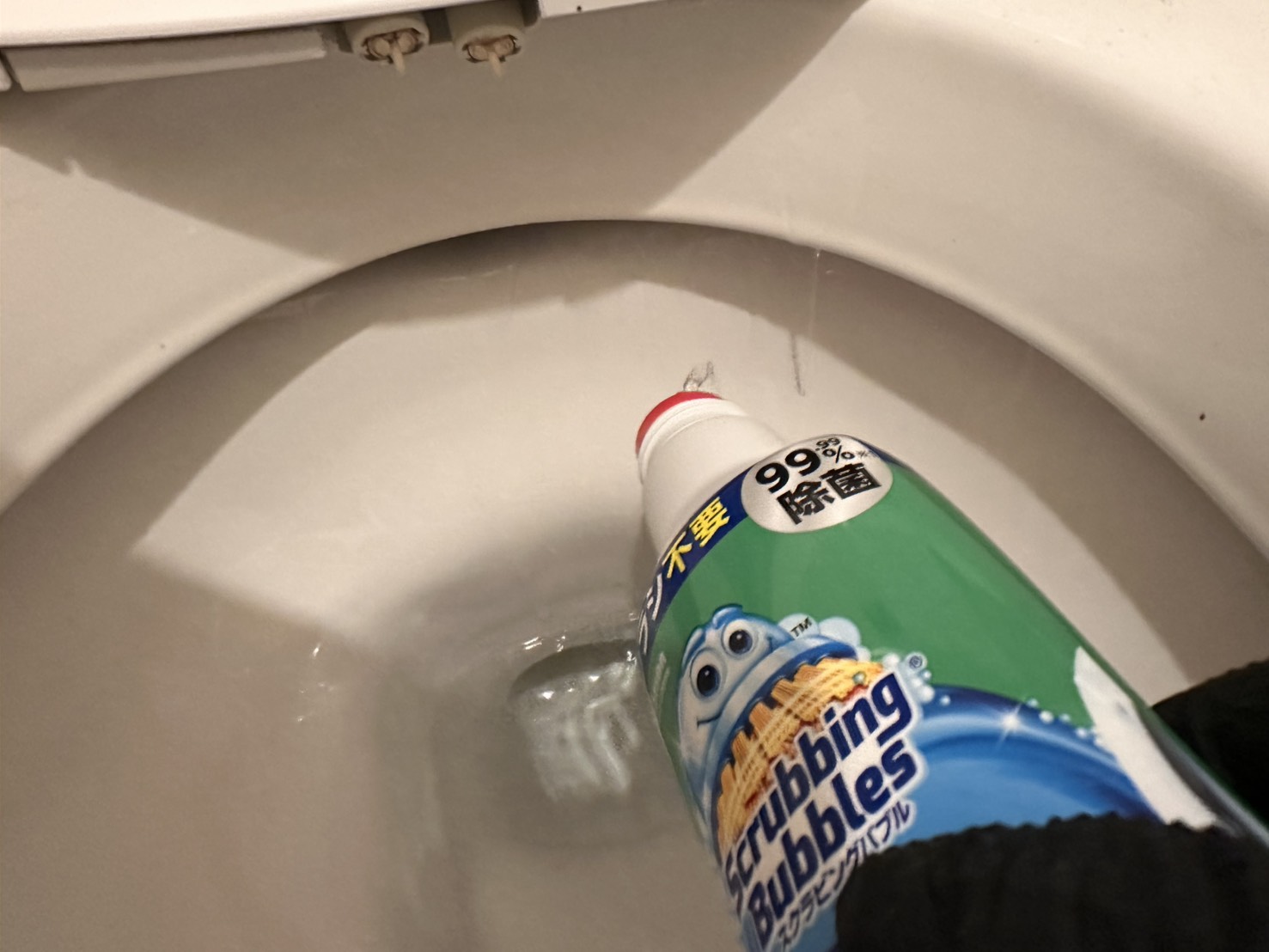スクラビングバブル超強力トイレクリーナーを便器のフチ裏にかけている様子