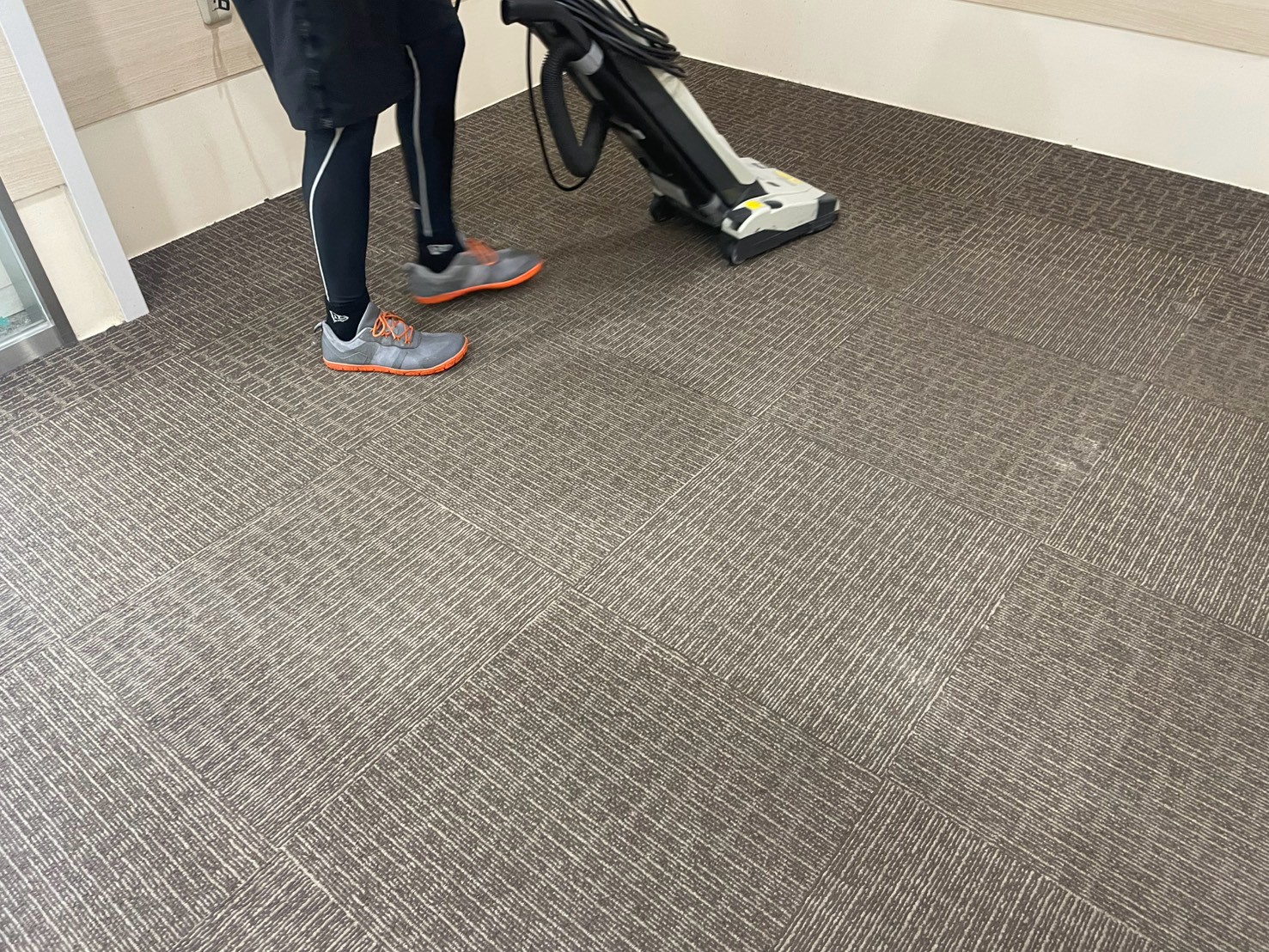 高槻市の施設でアップライト掃除機を使ってカーペットを除塵している様子