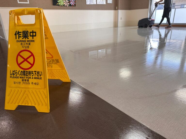 高槻市の施設で作業中看板を設置して2階食堂の床を洗浄している様子