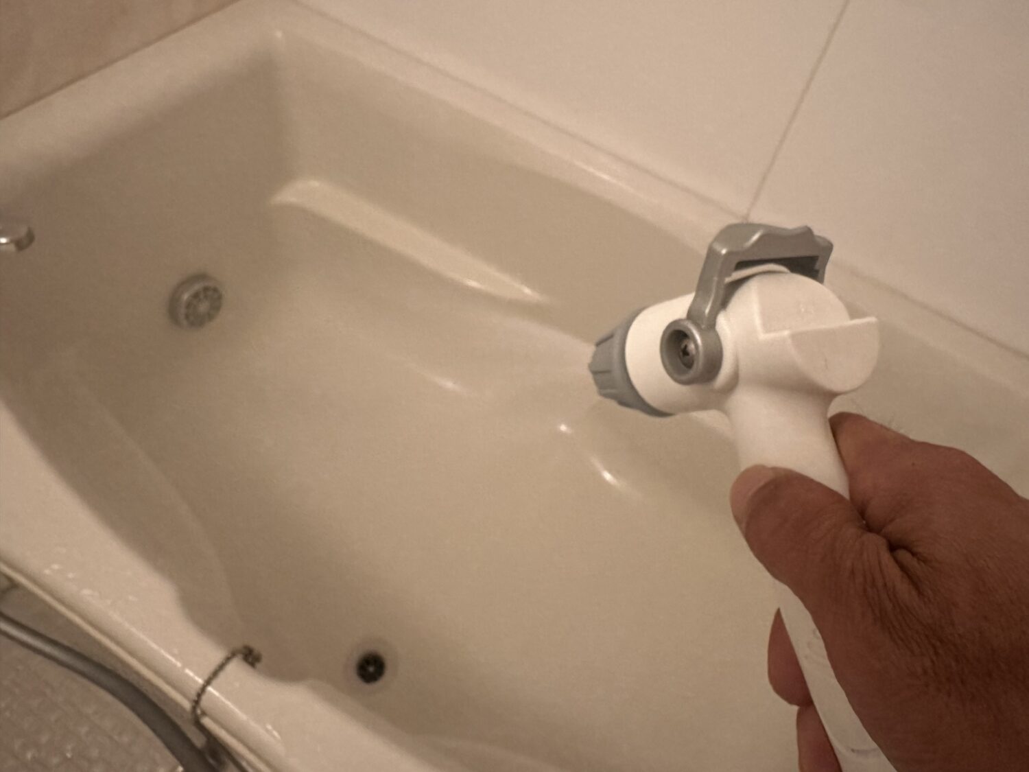 高水圧ガンを浴槽内へ向けて使用している様子